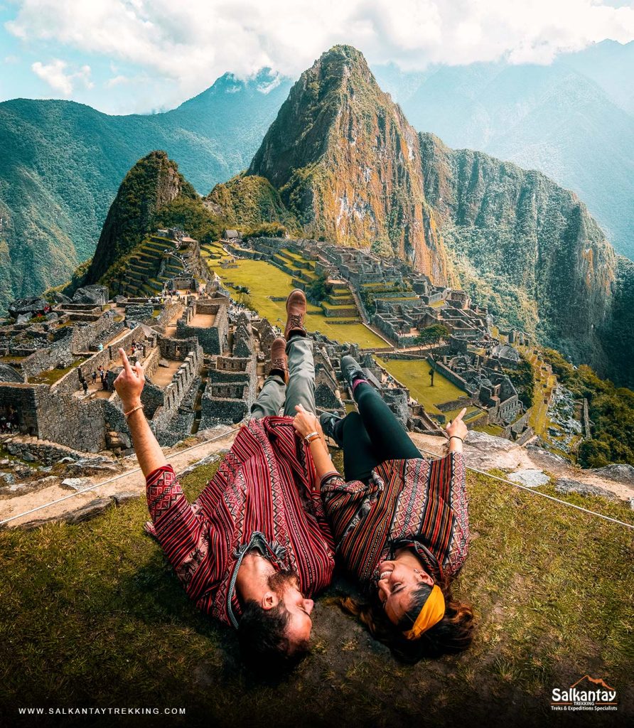 Casal de turistas com ponchos andinos em Machu Picchu