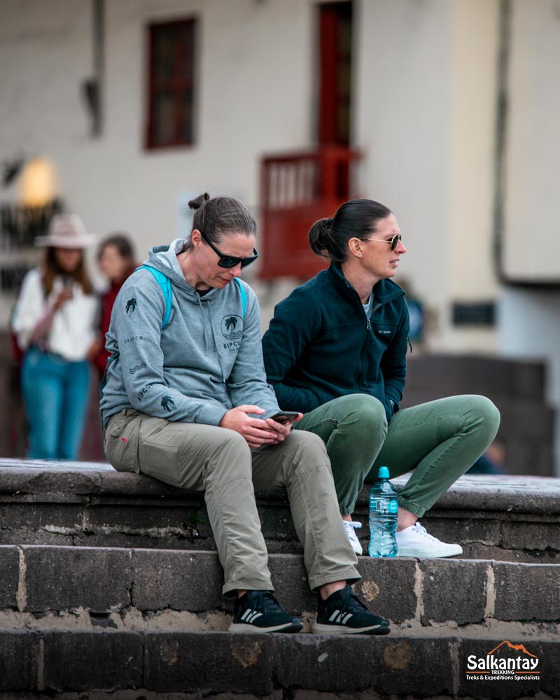 Dois turistas descansando na praça principal de Cusco.