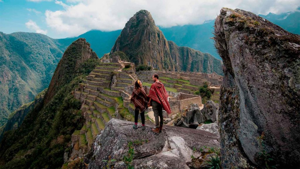 Casal de turistas em frente à majestosa montanha Machu Picchu em Cusco