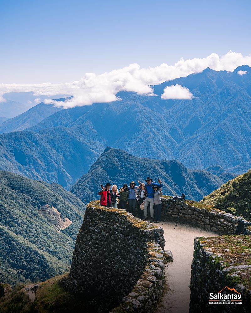 Grupo de turistas no sítio arqueológico de Phuyupatamarka em um cenário de montanhas.