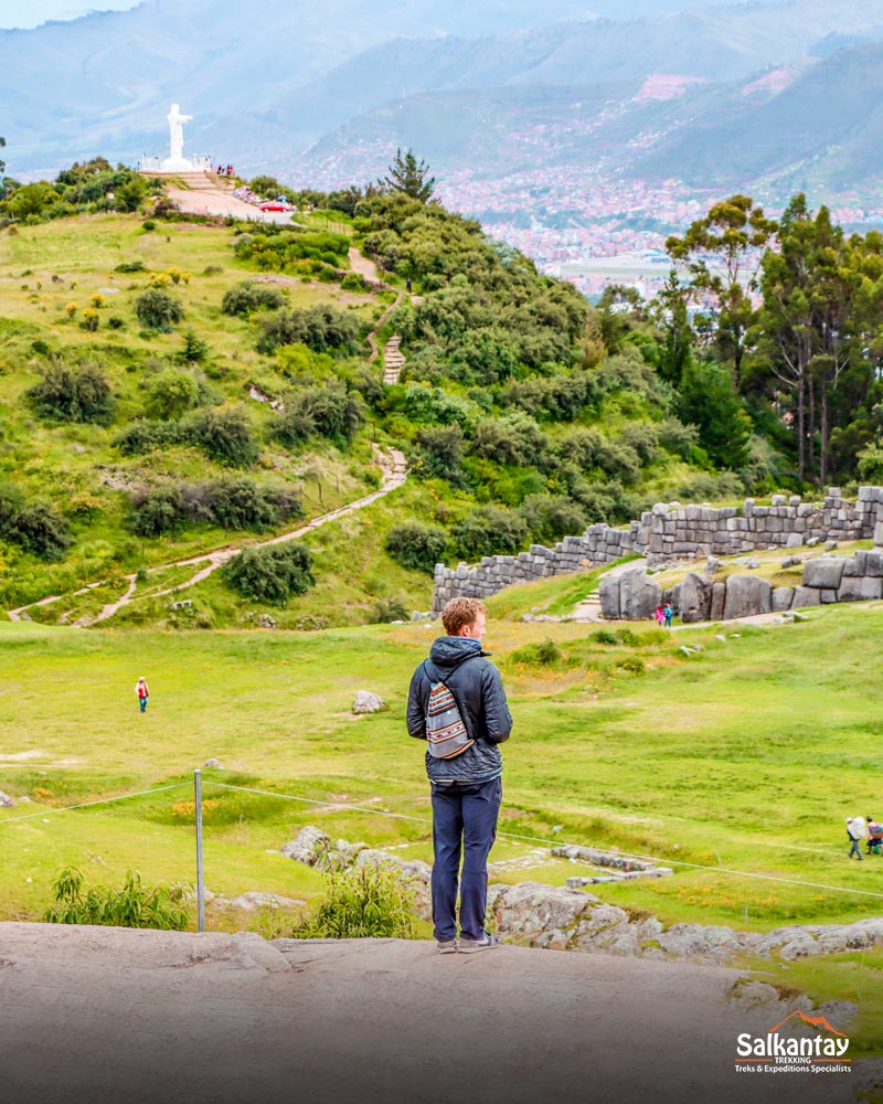 Turista sozinho em Sacsayhuaman olhando para a cidade de Cusco