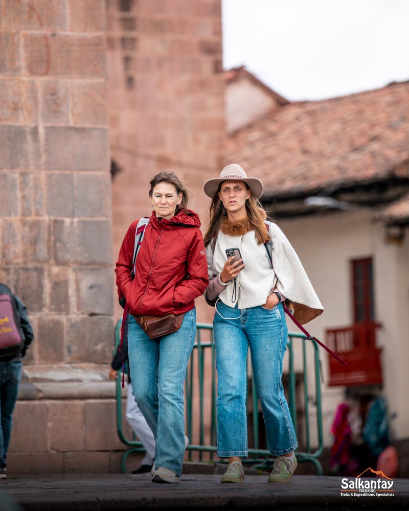 Pessoas passeando e aproveitando o dia na praça principal de Cusco.