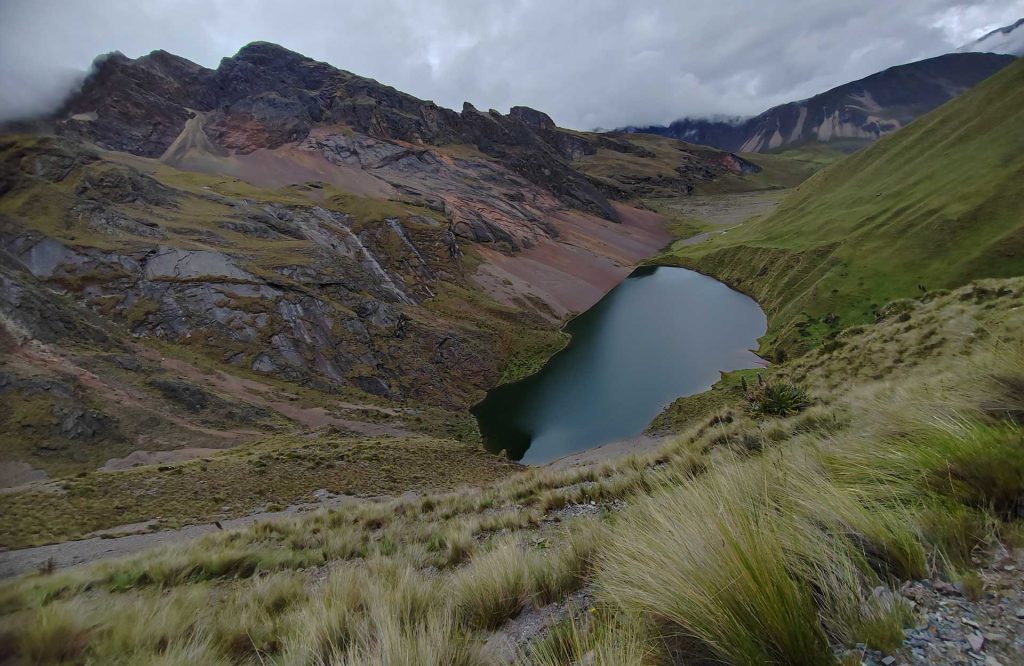 Impressionante vista da lagoa de Ancashcocha, rodeada por montanhas e flora andina.