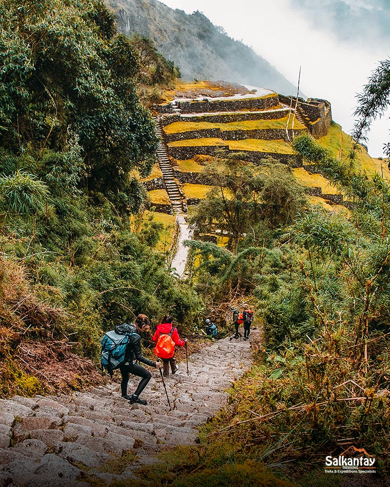 Descenso dos passageiros através do sítio arqueológico de Phuyupatamarca no Caminho Inca.