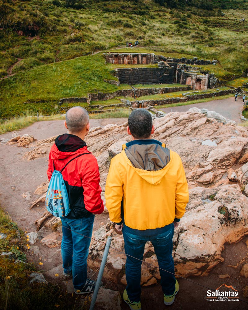 Dois turistas contemplam o sítio arqueológico de Tambomachay.