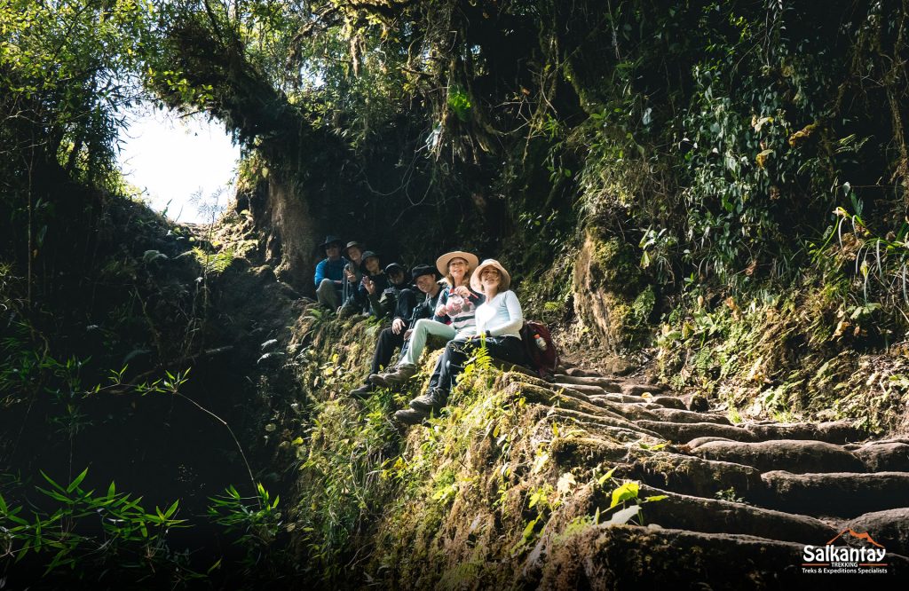 grupo de turistas sentados ao longo do trilho inca